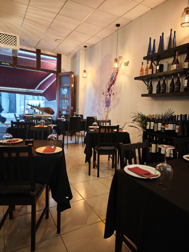 Sala interior de Ibéricos Gastro-Bar con mesas preparadas y selección de vinos